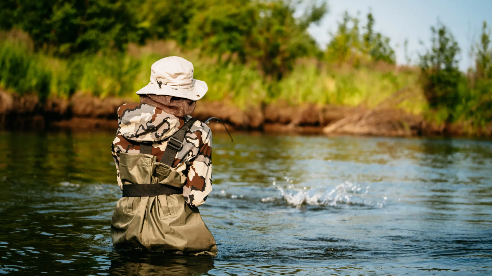 Angler fly fishing and reeling in a trophy fish on the Mulchatna River